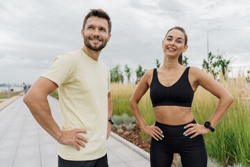 Fototapeta na wymiar A man and a woman train together. A personal trainer and a client teach fitness exercises. Instructors of friends use a fitness watch and a sports app. Confident, strong people in sportswear.