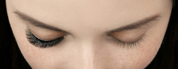 Close up shot of before and after procedure of lash extension. Macro shot of female green eyes with...
