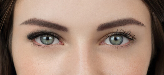 Close up shot of before and after procedure of lash extension, compared to mascara make up. Macro shot of female green eyes with long false volume lashes. Young woman with beautiful eyelash extensions