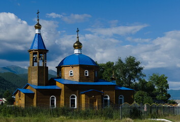 Russian orthodox church temple at among trees and clouds - obrazy, fototapety, plakaty