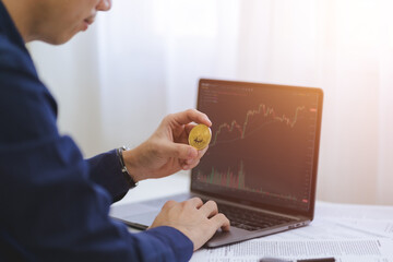 Businessman, investor, trader hold Bitcoin Cryptocurrency, using computer laptop with data analyzing paperwork for trading stock market, investing Bitcoin cryptocurrency. Investment and trade concept. - 640273849
