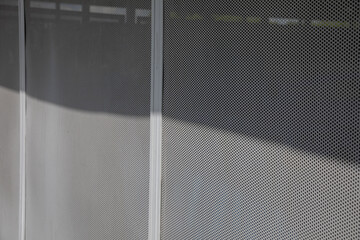 Perforated metal panel with round holes punctuated by a vertical strip.