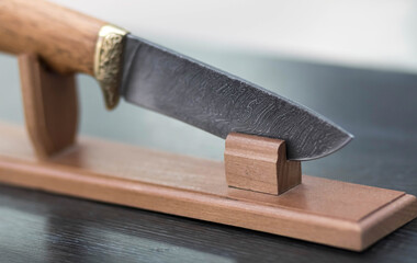 A beautiful steel knife on a wooden stand