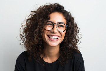 Obraz premium In this engaging portrait, a cheerful and satisfied woman with glasses exudes confidence against a pristine white background. Her happiness is palpable in her bright smile.