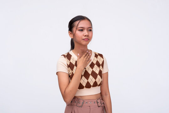 A young asian woman feels thirsty. Touching her parched throat. Isolated on a white background.