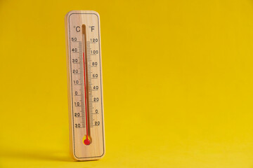 Wooden outdoor thermometer yellow background. - obrazy, fototapety, plakaty