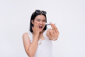 A young excited asian woman holding a miniature car. Can also represent an owner with new vehicle...