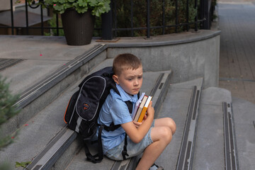 Depressed school boy sitting outside of school