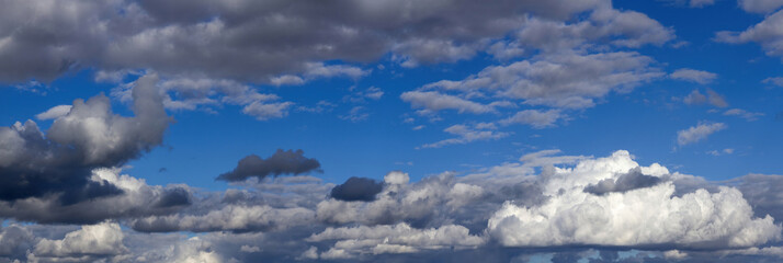 Panorama of nice blue sky with white and gray cumulus clouds