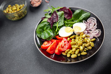 edamame bean salad vegetables, tomato, boiled egg, salad dressing appetizer meal food snack on the table copy space food background rustic top view keto or paleo diet vegetarian vegan food no met