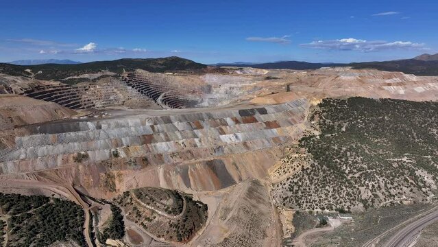 Aerial copper gold open pit mine Ely Nevada 4K 4. Copper and gold discovered in Ely Nevada in late 1800's. Boom town along historic Pony Express trail. Ore transported to Japan for smelting.