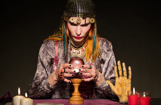 Fortune teller consulting crystal ball while predicting future