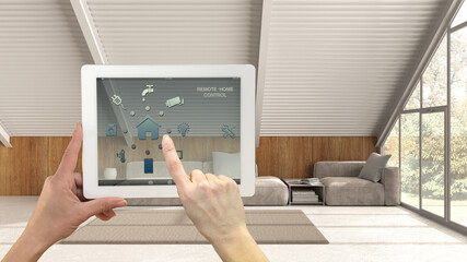 Smart remote home control system on a digital tablet. Device with app icons. Modern minimal mansard living room in the background, architecture interior design