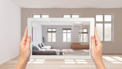 Augmented reality concept. Hand holding tablet with AR application used to simulate furniture and design products in empty wooden interior, minimal living room, sofa and staircase