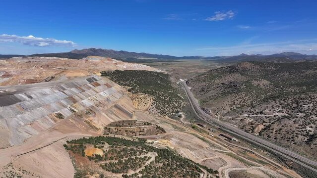 Aerial gold copper mine to mountain Ely Nevada 4K 1. Copper and gold discovered in Ely Nevada in late 1800's. Boom town along historic Pony Express trail. Ore transported to Japan for smelting.
