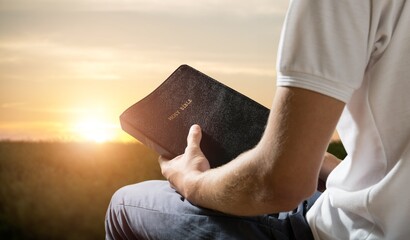 hand of young male prayer reading bible