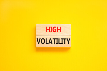 High volatility symbol. Concept words High volatility on beautiful wooden blocks. Beautiful yellow table yellow background. Business high volatility concept. Copy space.