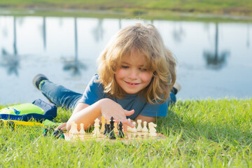 Clever concentrated and thinking child playing chess. Dream kids and childhood concept.