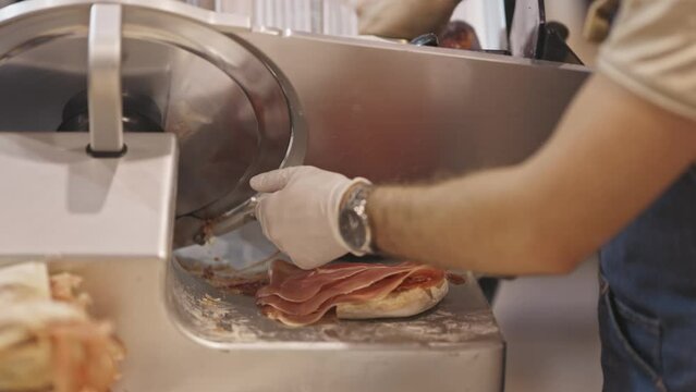 Ham being sliced into pieces using a slicing machine