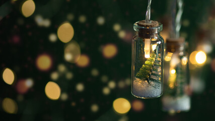 Creative Christmas garland lights with bokeh. Christmas tree in a glass jar with snow. Christmas greeting card.