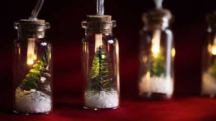 Creative Christmas garland lights with bokeh. Christmas tree in a glass jar with snow. Christmas greeting card.