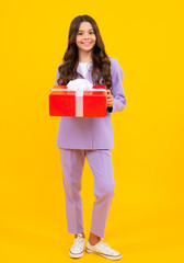 Teenager kid with present box. Teen child girl giving birthday gift. Present, greeting and gifting concept.