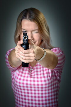 a beautiful woman aims a gun