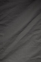 Close-up of a wrinkled and gray cotton cloth or textile. Abstract high resolution full frame textured background in black and white, copy space.