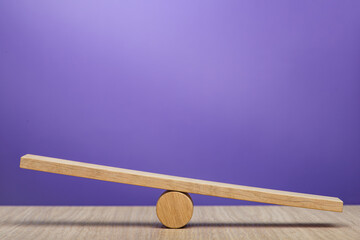 Empty wooden scales on a purple background. The concept of equilibrium and balance. High quality...