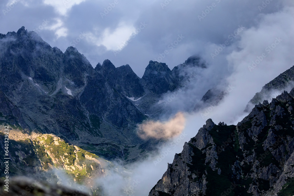 Wall mural sunlight on mountains in clouds