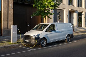 charging electric white delivery van in the city - obrazy, fototapety, plakaty