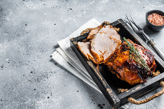 Glazed Roast Pork Roll In Wooden Tray With Herbs. Gray Background. Top View. Copy Space