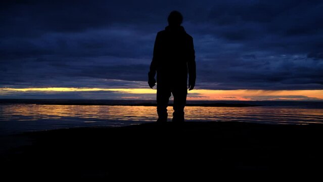 un homme devant un coucher de soleil sur la mer