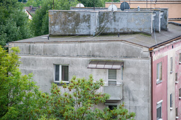 Ściana i dach brudnego budynku z oknami i zielenią