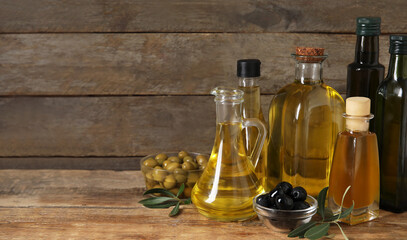Healthy olive oil on wooden background with space for text