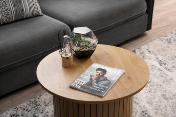 Coffee table with florarium, lamp and magazine in modern living room - Powered by Adobe