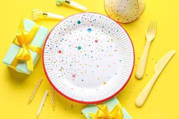 Paper disposable plate with different party decor on yellow background