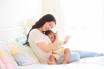 Mother nursing baby at home. Breastfeeding infant.