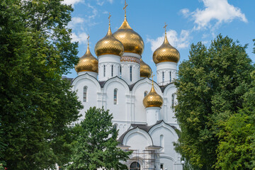 Fototapeta na wymiar Yaroslavl, Russia, July 4, 2023. The golden domes of the Assumption Cathedral among the trees of the park.