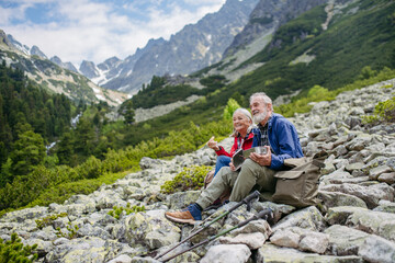 Active senior couple hiking together in autumn mountains.