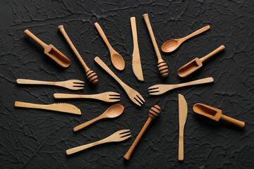 Different wooden kitchen utensils on black background