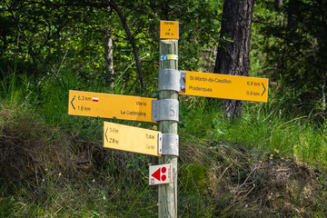 Trail signpost. On the Colorado Provencal Trail. Abstract Rustler canyon moher cliffs landscape. Provencal Colorado near Roussillon, Southern France. Red sand background
