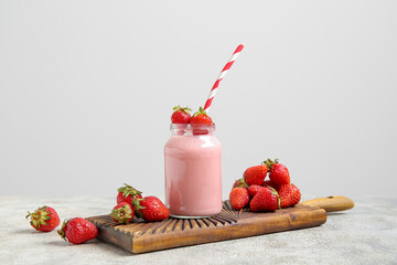 Mason jar of tasty strawberry smoothie on table