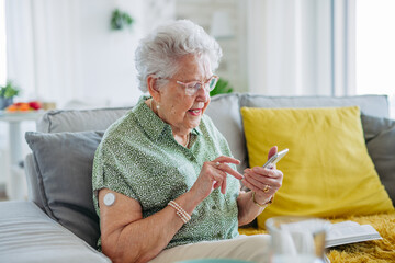 Senior diabetic woman checking her glucose data on smartphone.