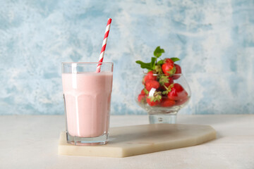 Glass of tasty strawberry smoothie on table