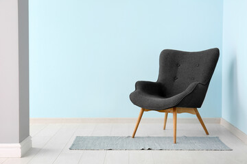 Grey armchair near blue wall