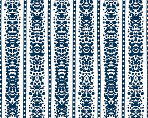 Ethnic seamless pattern of dark blue vertical stripes with rorschach ink blot texture; monochrome geometric vector background of abstract lace