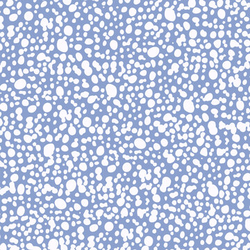 Gentle seamless grainy texture of white blots and droplets on pastel blue background; grunge bobbly vector surface design