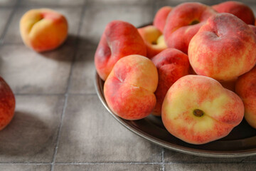Plate with sweet fig peaches on grey tile background