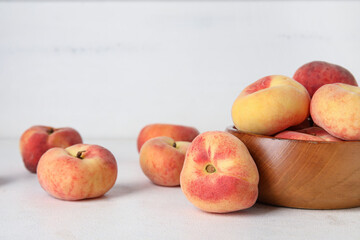 Wooden bowl with sweet fig peaches on white background